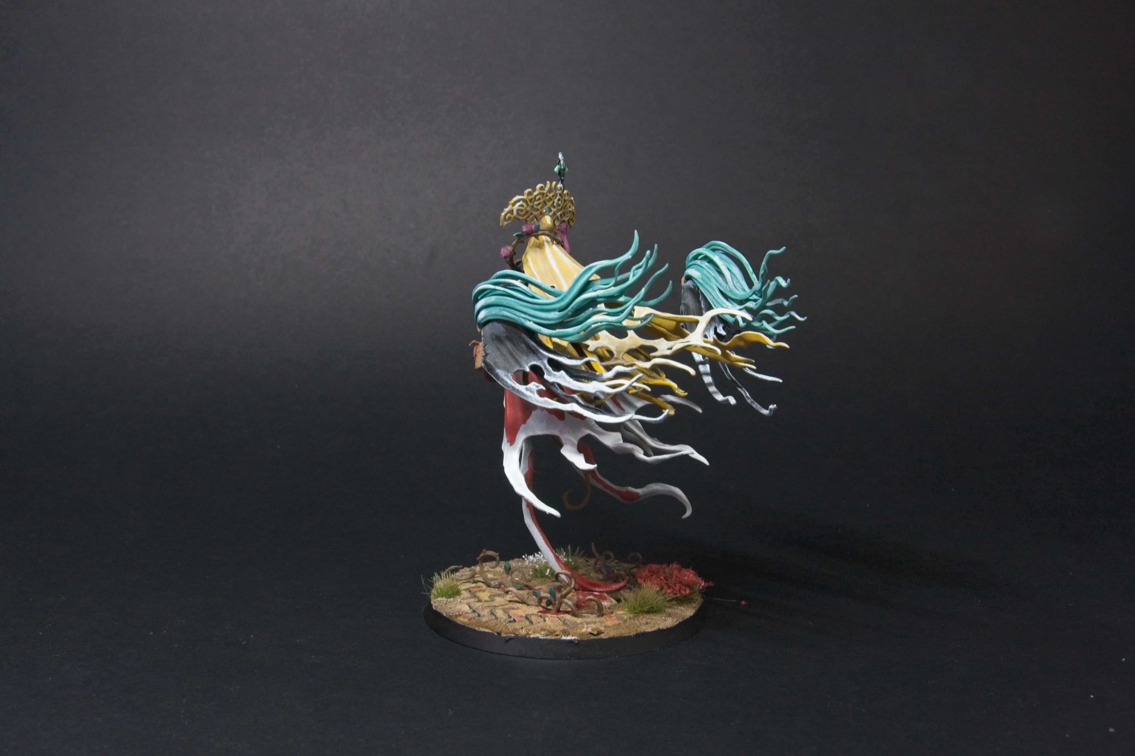 A view of Olynder's back; multiple layers of golden cloth, hair, and white cloak.