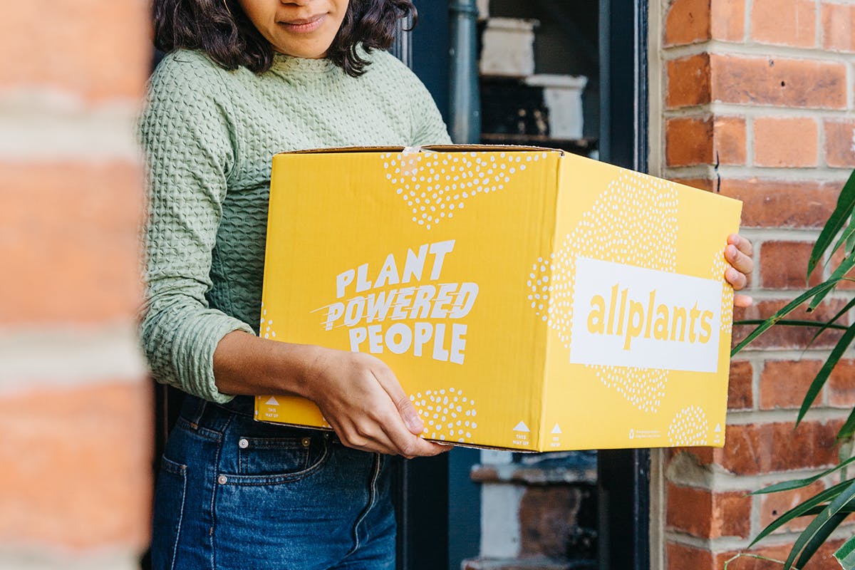 person holding allplants box