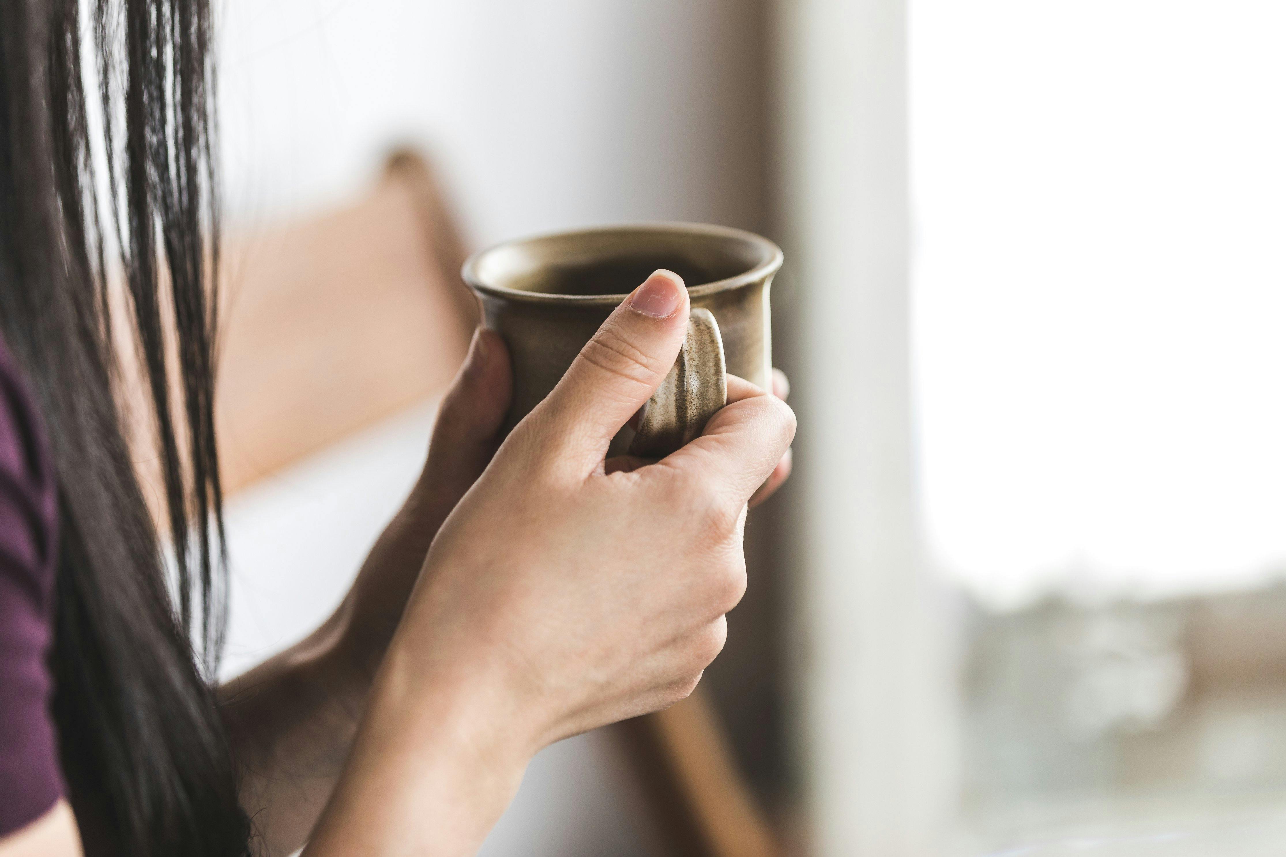 someone drinking a cup of coffee