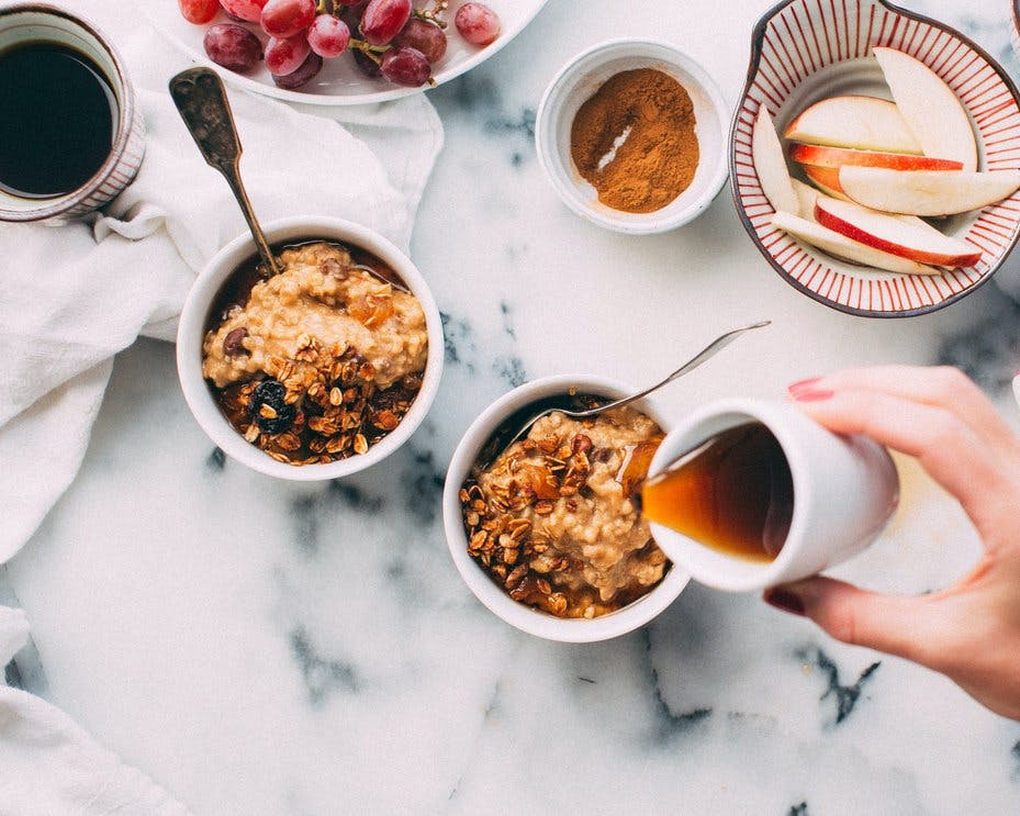 two bowls of museli with syrup and apple slices