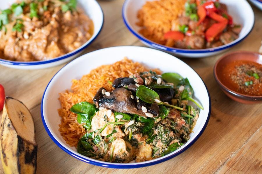 Three bowls of Ghanian food on wooden table