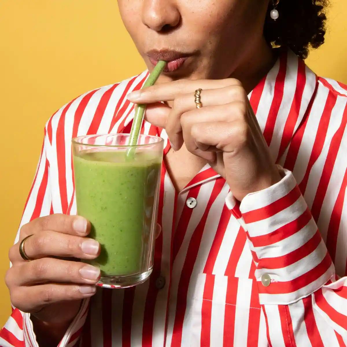 Girl drinking allplants green smoothie