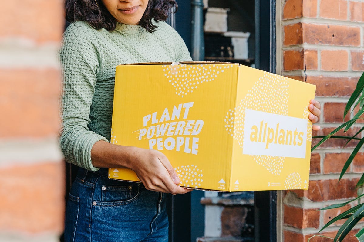 A woman holds an allplants box