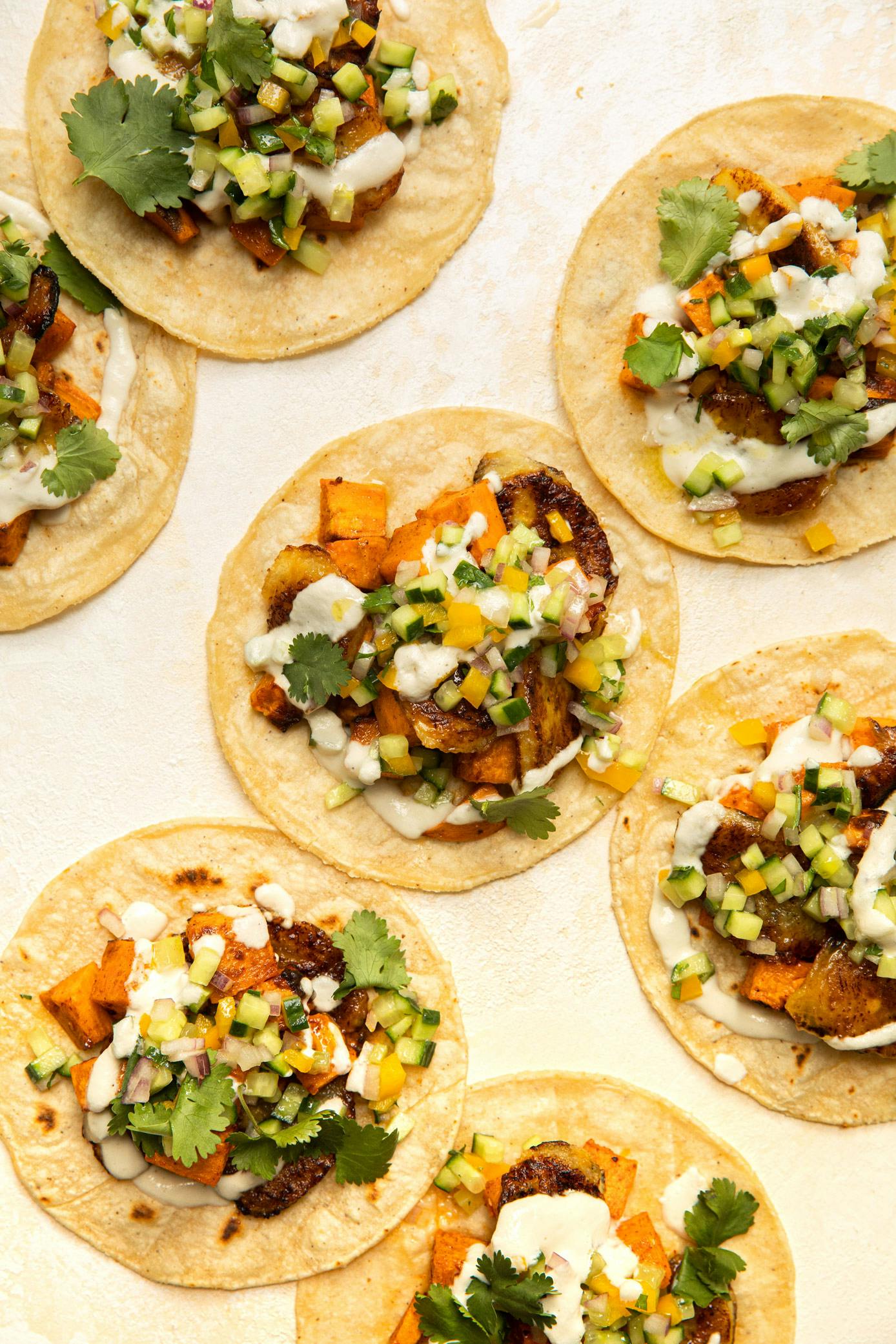 sweet potato and plantain tacos on off-white background