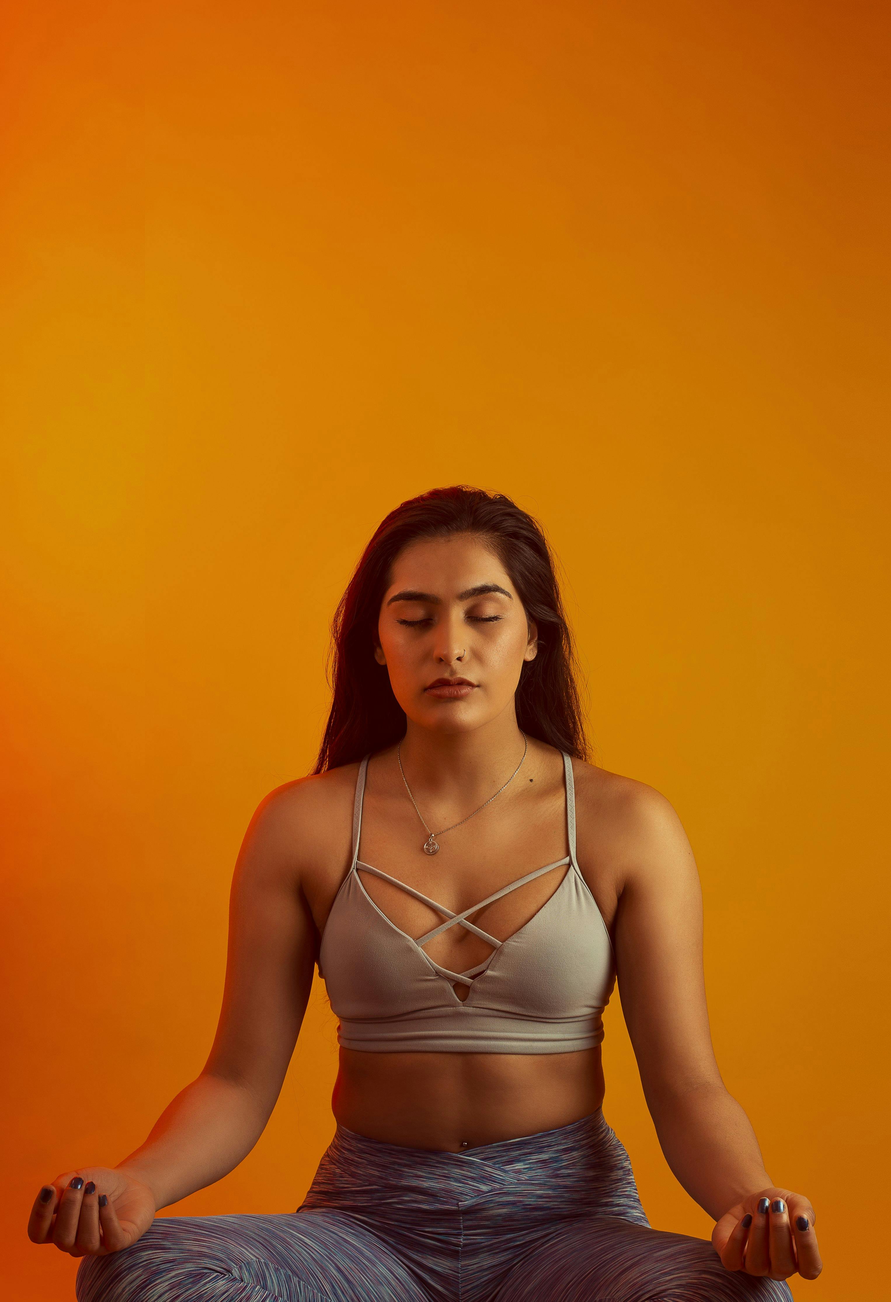 woman doing yoga against orange background