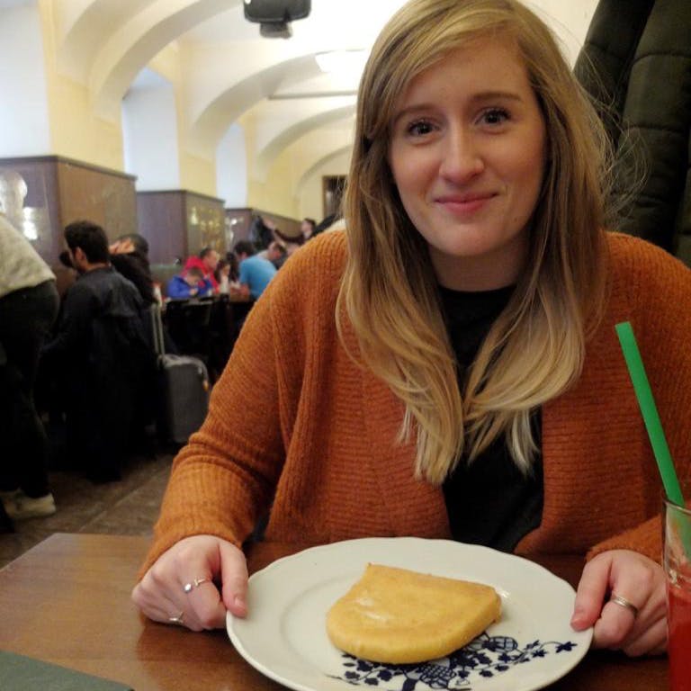 Woman holding plate with piece of fried cheese the size of a slice of bread