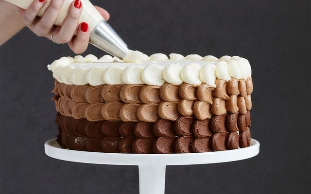 CAKE BEING ICED ON A STAND