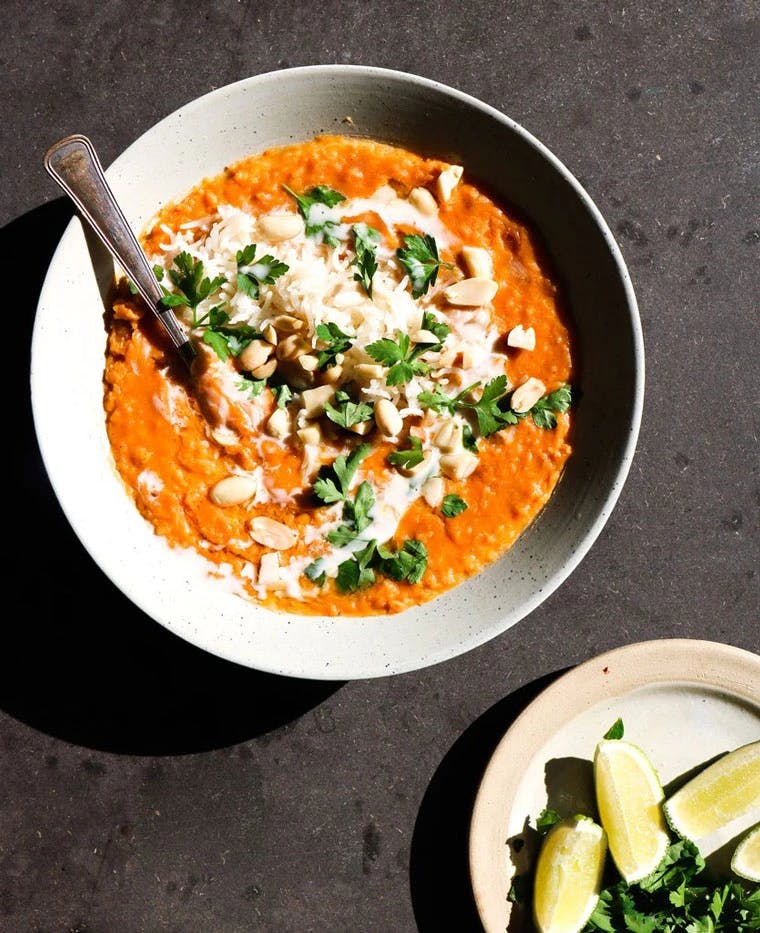 daal in bowl next to plate of lime wedges