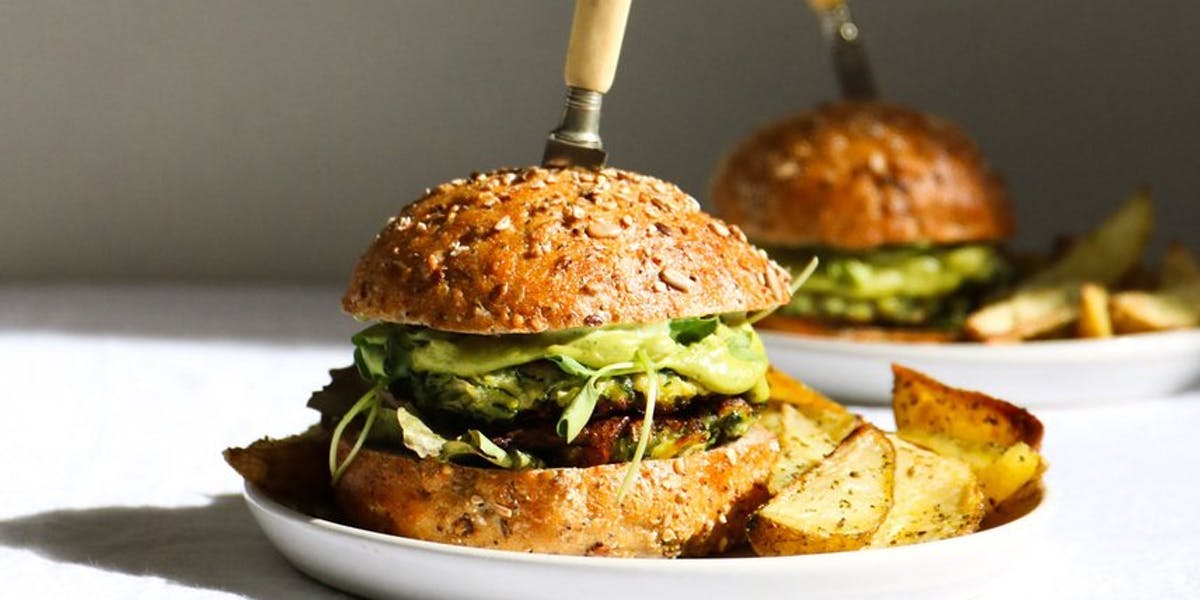 fritter burger on plate with potato wedges