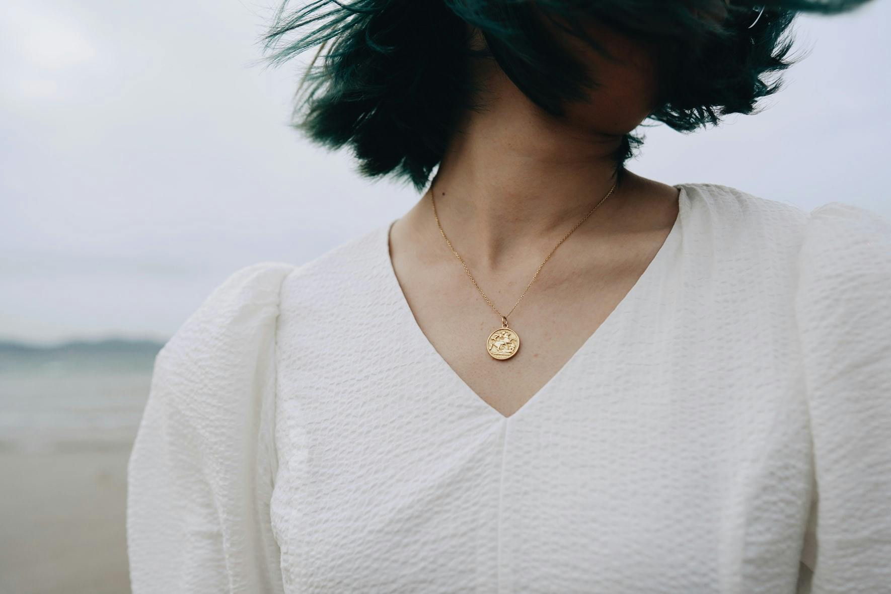woman wearing gold necklace
