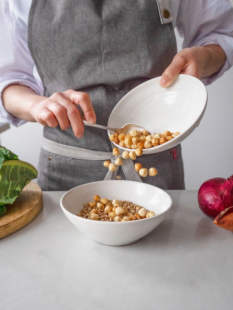 image of joey pouring blanched hazelnuts into a bowl