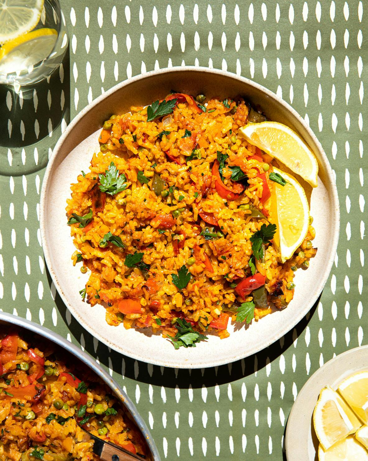 plate of paella with lemon wedges