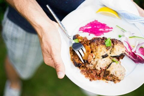 person holding plate of moussaka
