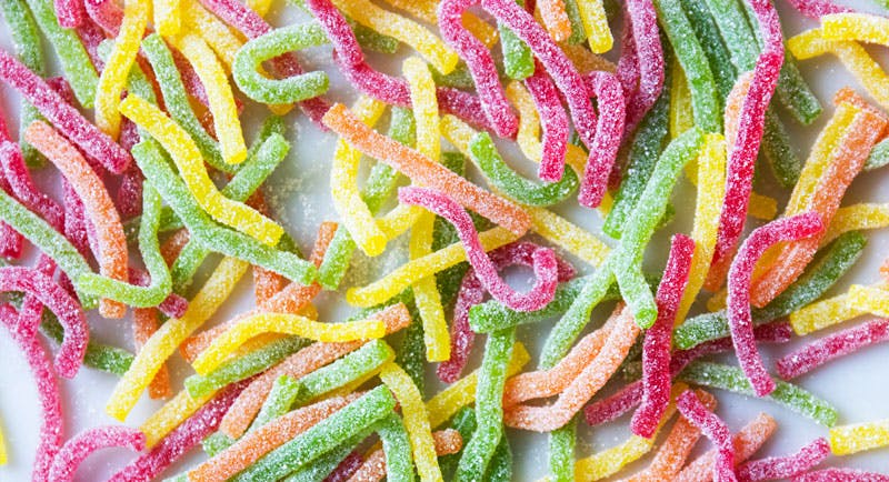 Close up image of fizzy worms spread over a table, taken from a birdseye view.