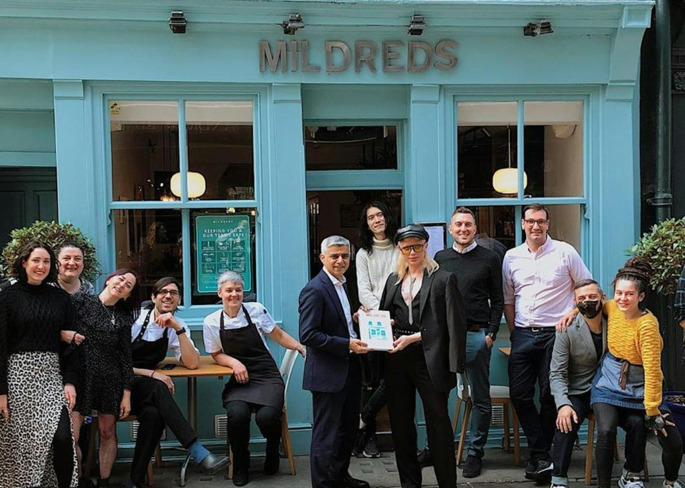 a group of people outside a cafe