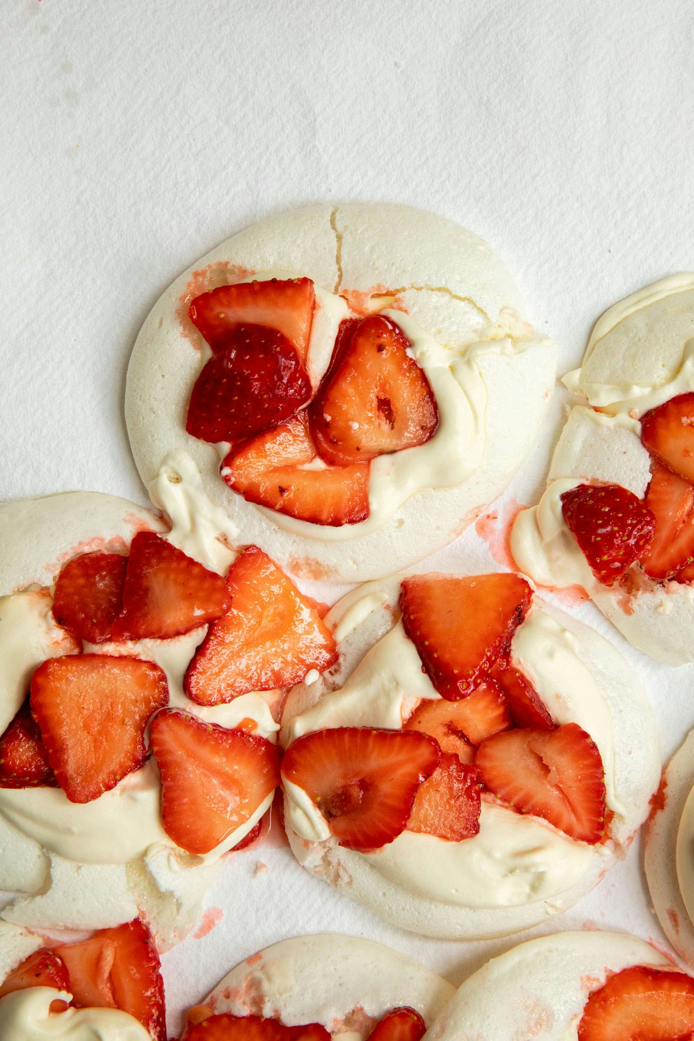 close up shot of meringues with strawberries