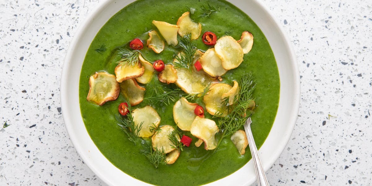 parsnip and kale soup in white bowl with spoon