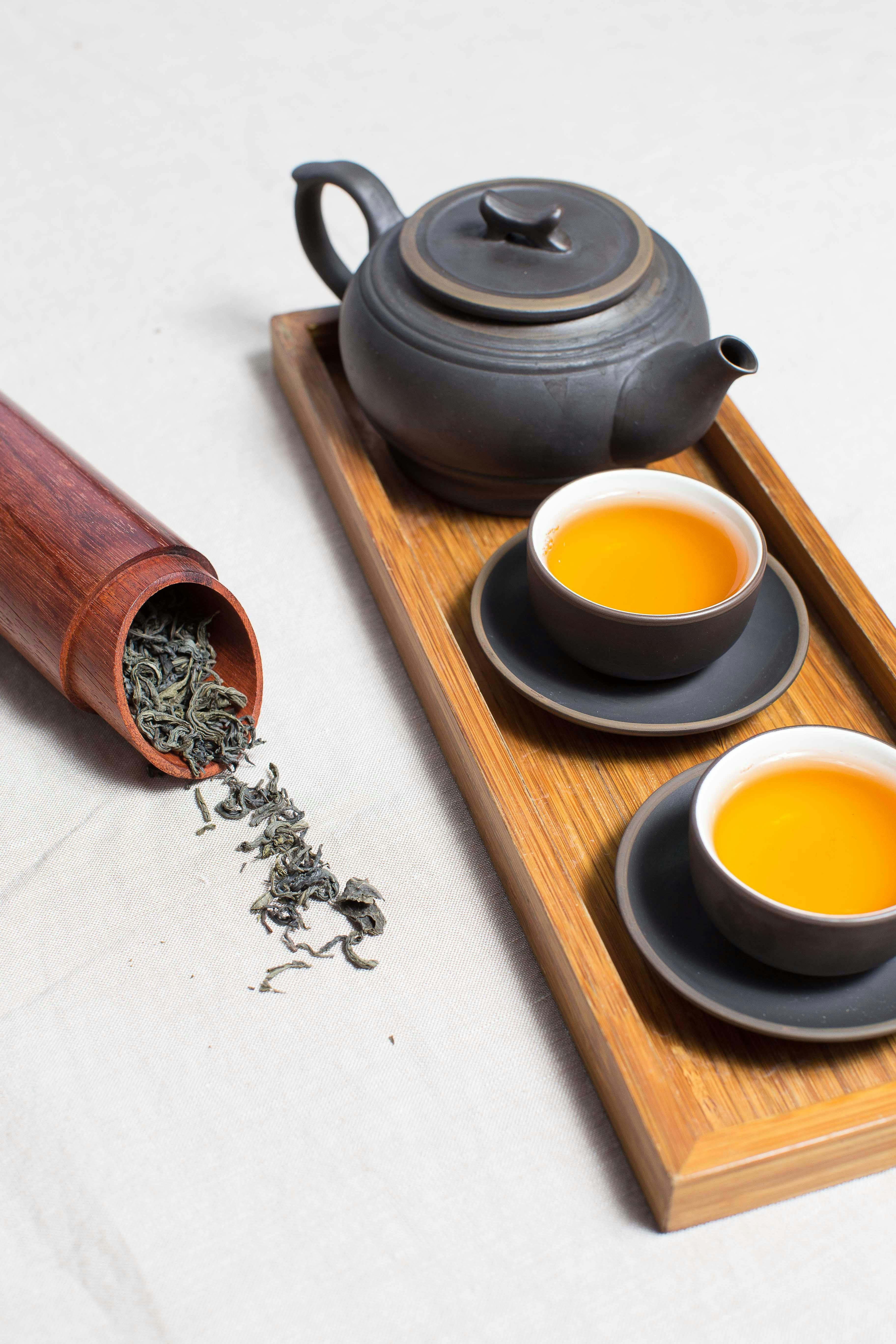 teapot with cups and dried leaves