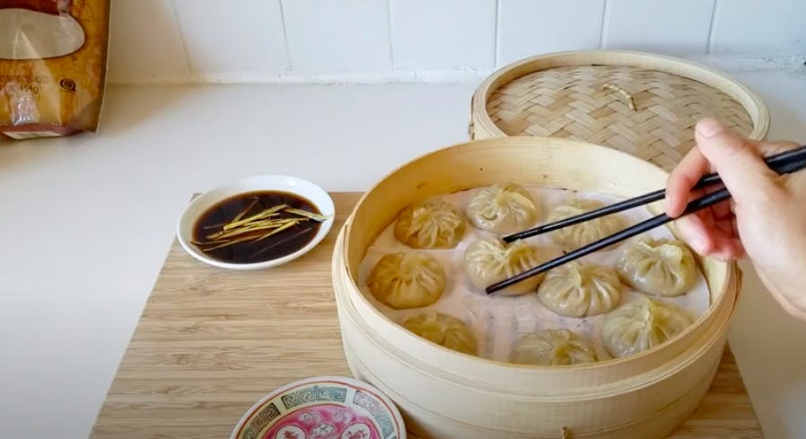 Xialongbao in steamer next to dipping sauce