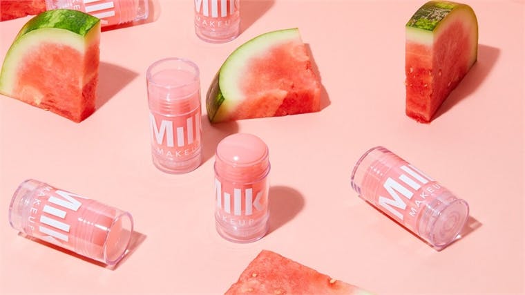 milk serum sticks on pick background next to slices of watermelon