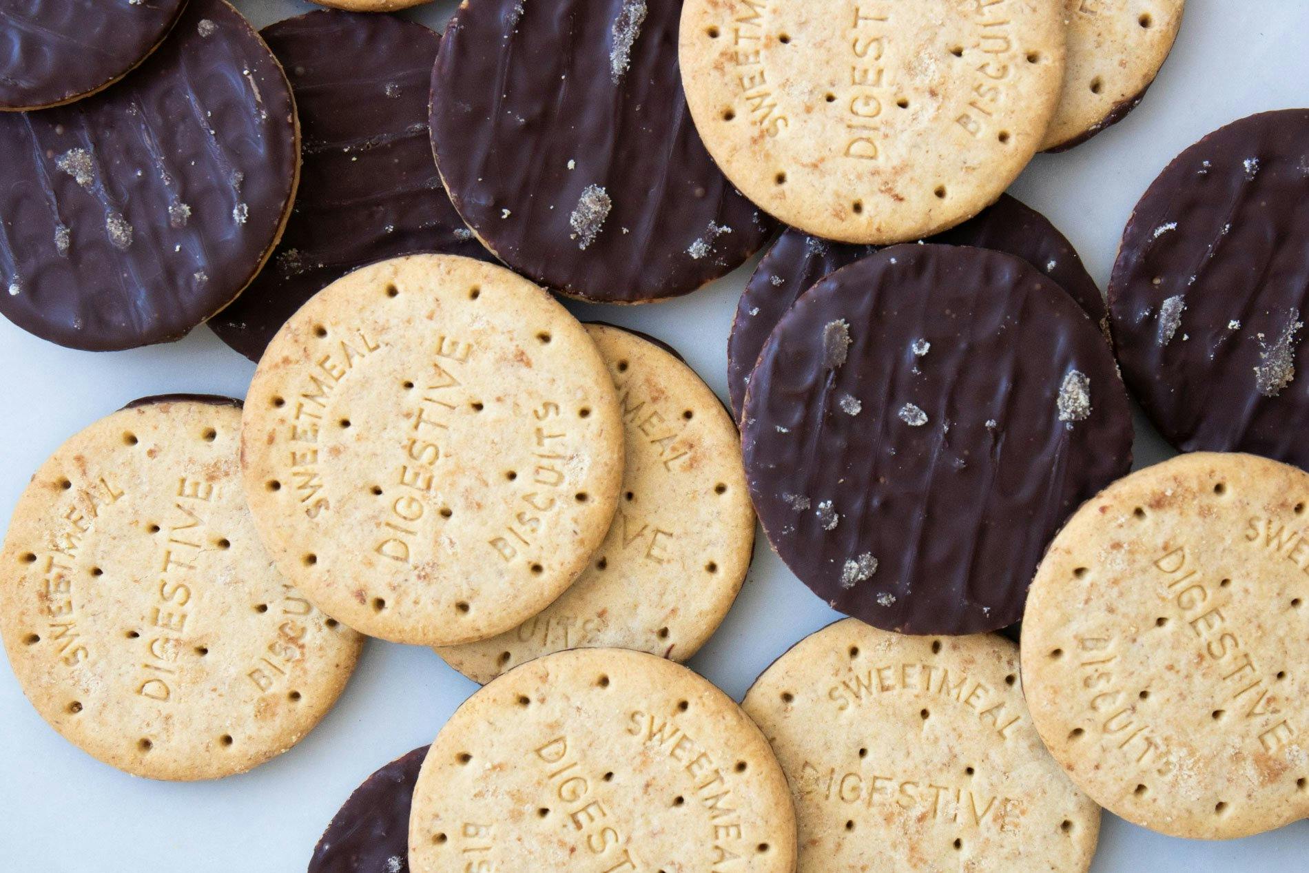 Close up image of chocolate digestives spread over a table.