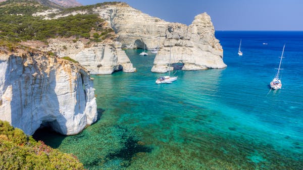Panoramic view of yachts anchored by the white Kleftiko cove on the south coast of Milos island, Cyclades, Greece