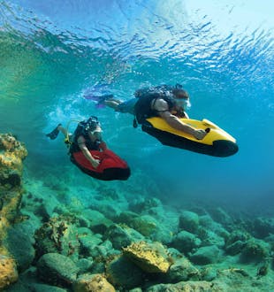 Two men using Seabob dive equipment in clear water