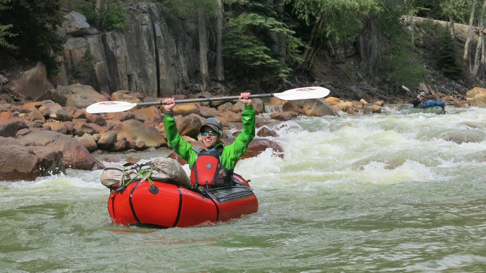 Gear you absolutely need when running cold or remote whitewater: helmet, drysuit, personal floatation device (aka PFD), and throw bag (out of site). Bonus: water-resistant Hyperlite Mountain Gear Porter Pack for multi-day adventures. Photo by Kreston Johnson