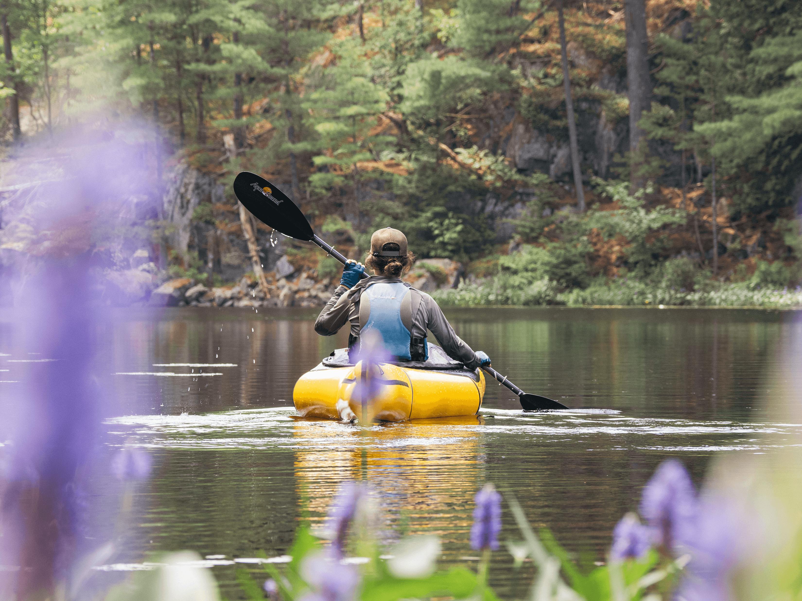 Paddling the Aluetian packraft with purple flowers