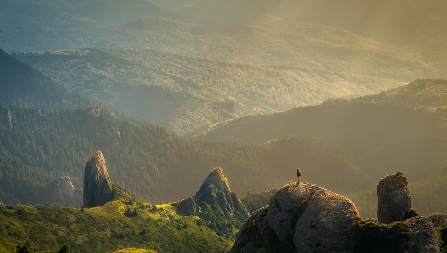 Personne sur un rocher au milieu de la nature qui regarde l'horizon et toutes les possibilités qu'il a, comme en finance où il peut investir de différentes manières mais qu'il vaut qu'il choisisse la solution d'investissement la plus responsable.