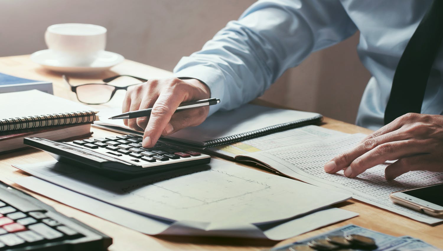 Personne, dont on voit les mains, qui calcule sur quelle solution serait-il préférable de placer sa trésorerie. Cette action deviendrait inutile si cette personne se tournait vers les professionnels d’Alphacap et leurs conseils en placement financier.