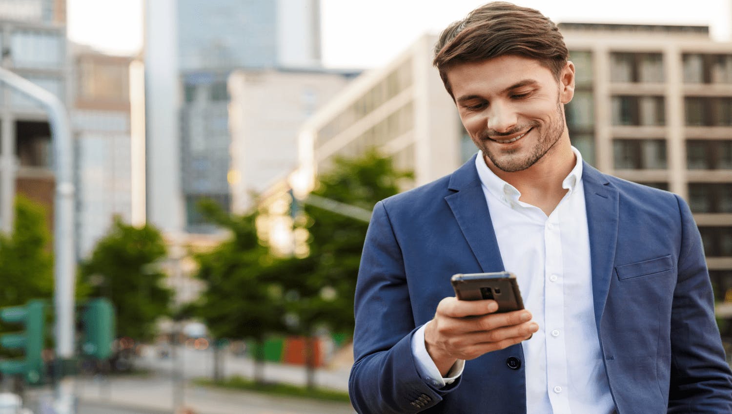 Jeune homme heureux de pouvoir suivre ses placements et la construction de son patrimoine en temps réel depuis son téléphone.