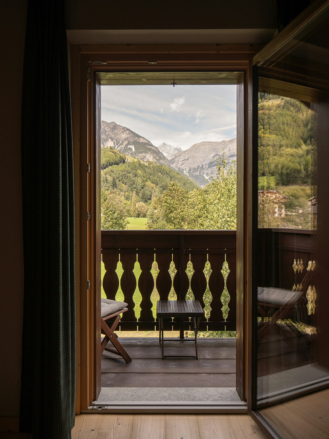Vista panoramica sulle Alpi dal balcone in legno tradizionale con ringhiera intagliata