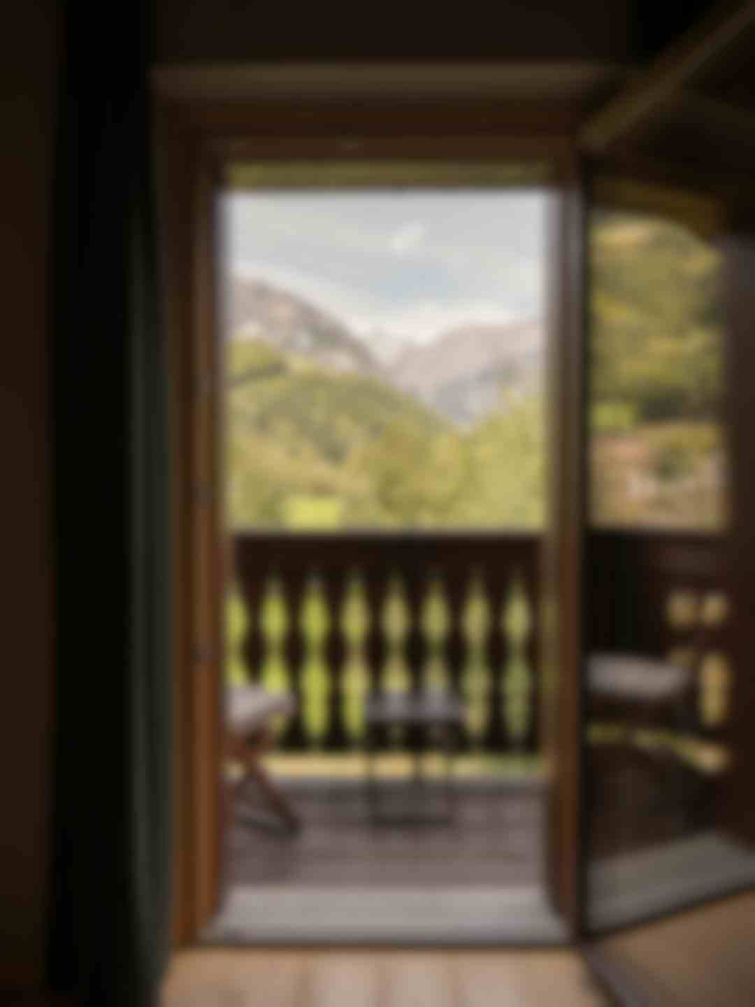 Vista panoramica sulle Alpi dal balcone in legno tradizionale con ringhiera intagliata