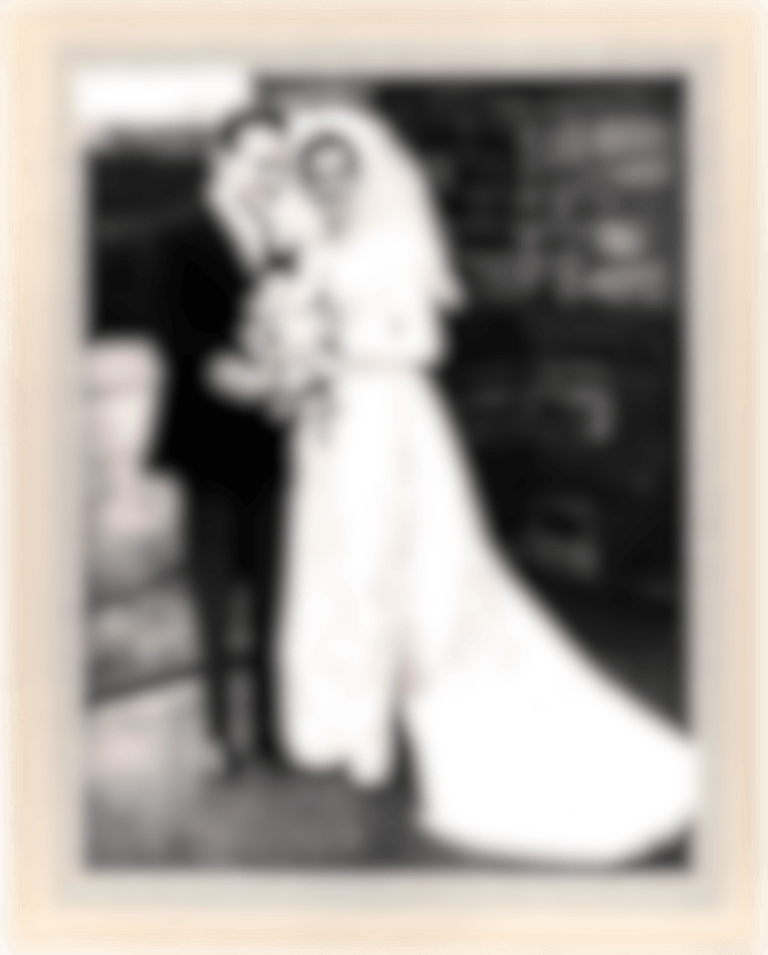 Foto di matrimonio in bianco e nero di coppia elegante davanti a muro in pietra, epoca vintage