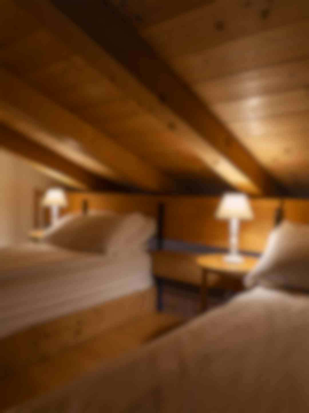 Due letti singoli a soppalco, travi e soffitto in legno.