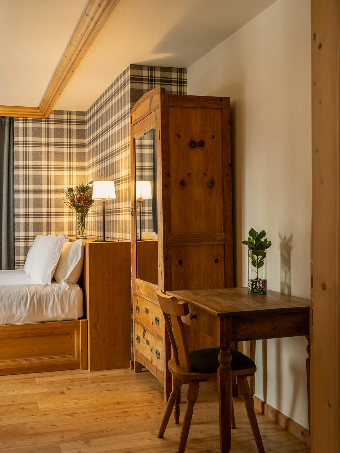 Stanza in legno con armadio antico e carta da parati in stile tartan.