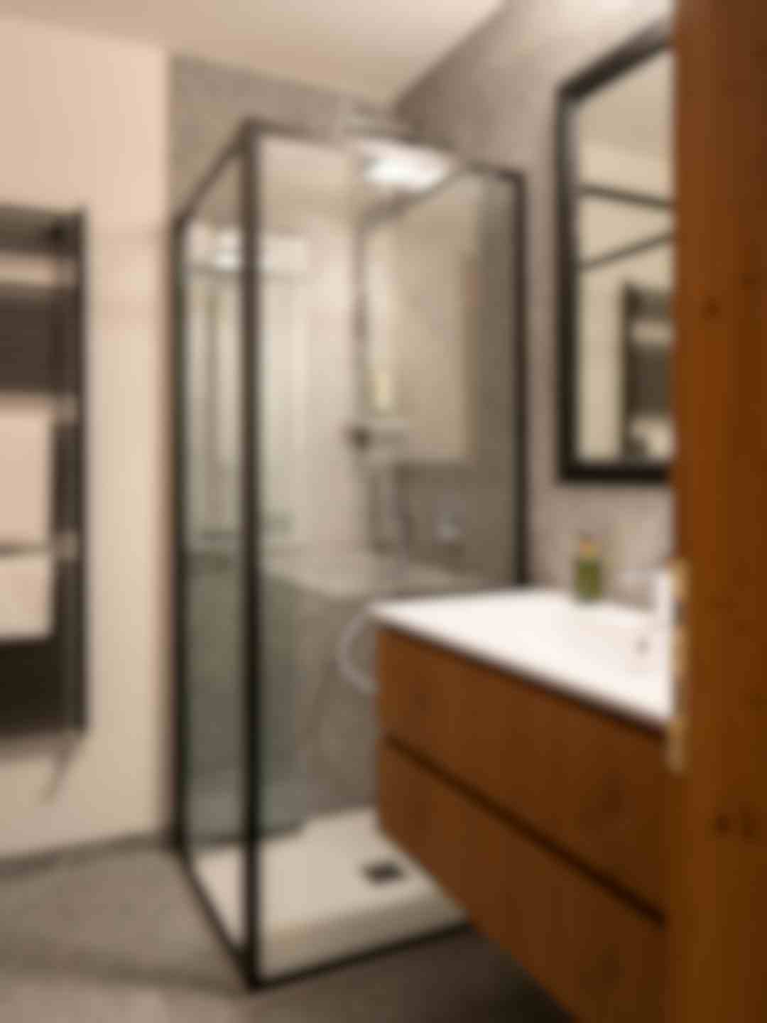 Doccia con rain shower e pietra di Luserna. Mobile lavabo in rovere e grande specchio.