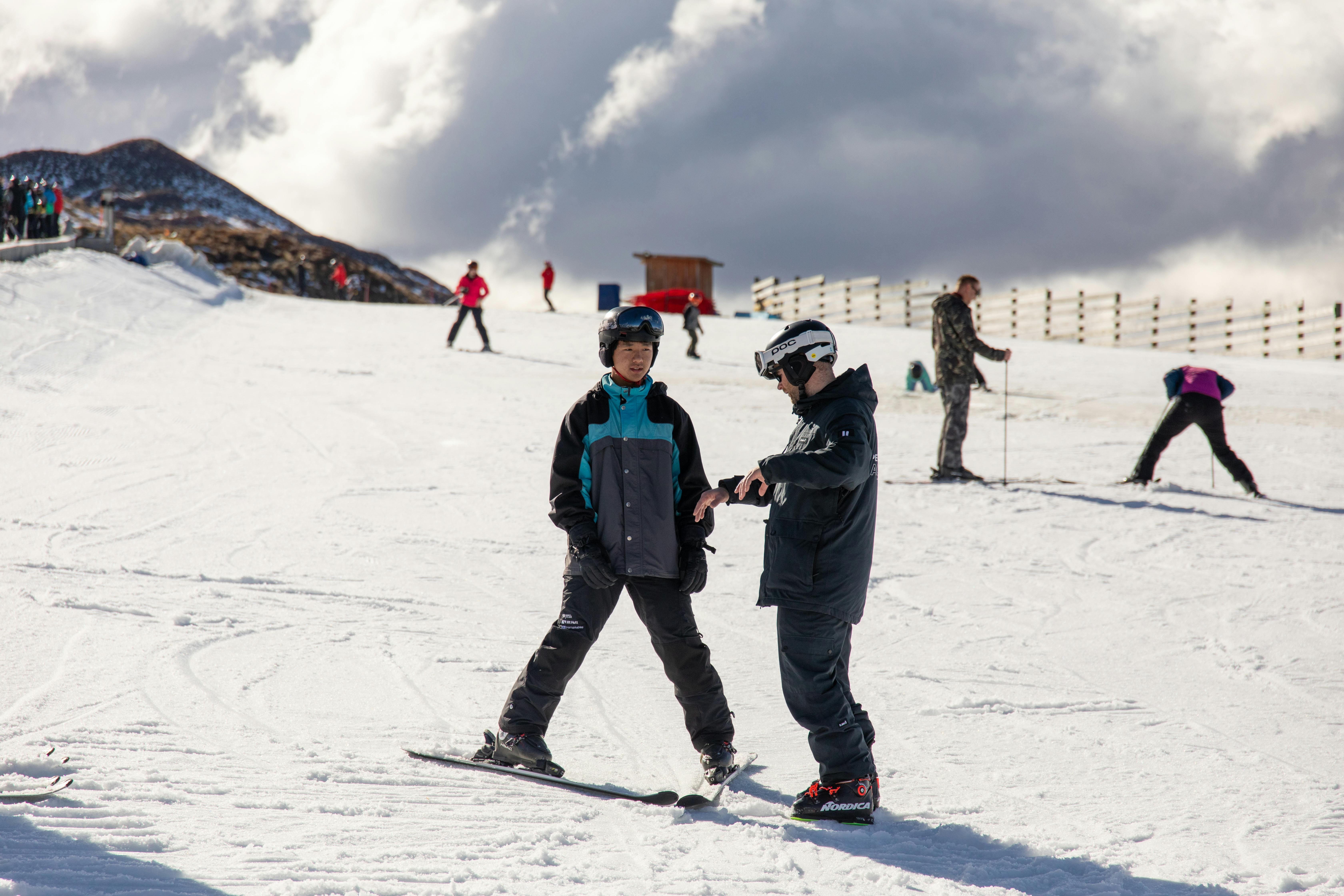 Two people skiing on a snowy slope.