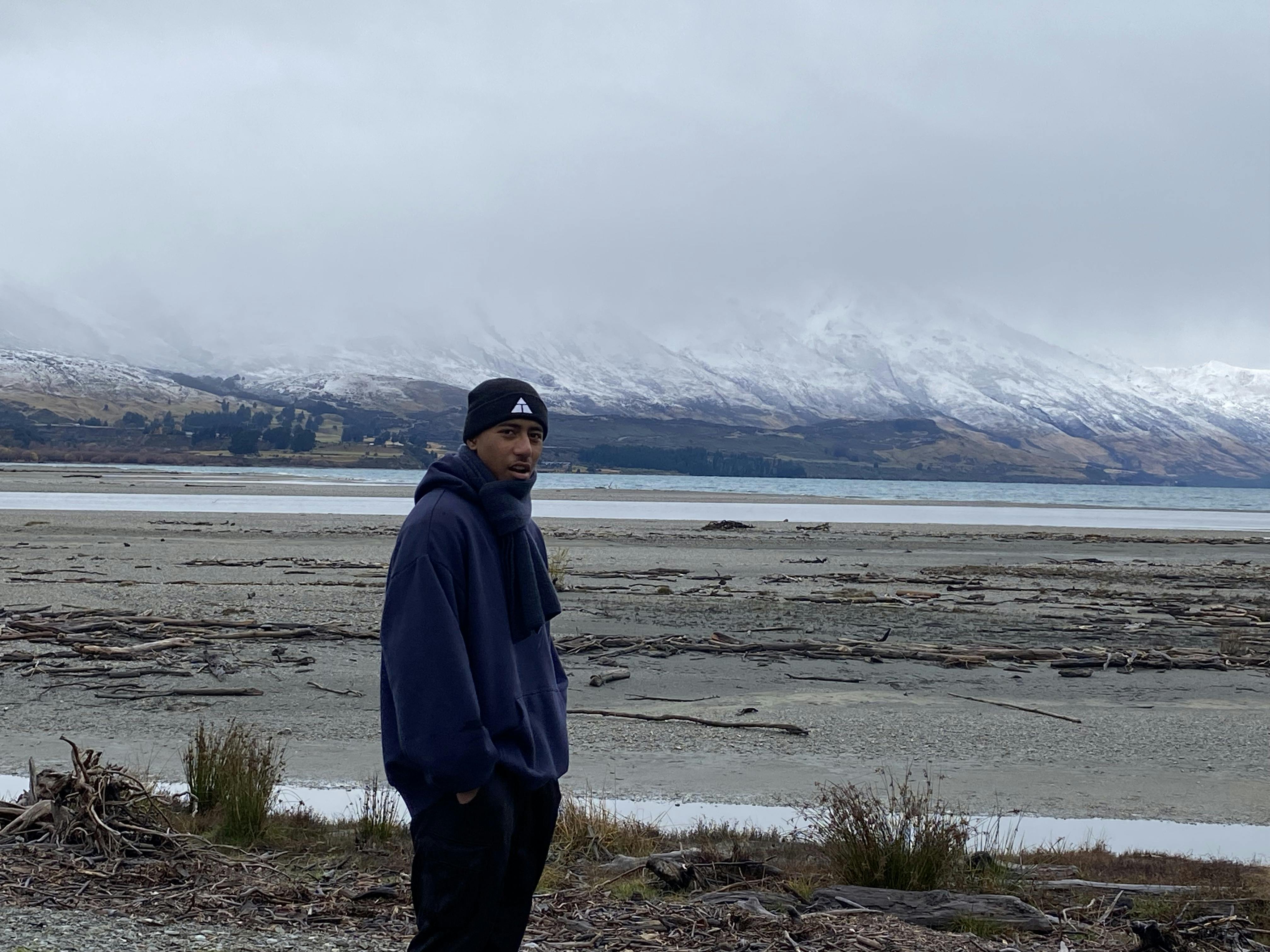 boy by lake with mountains in the background
