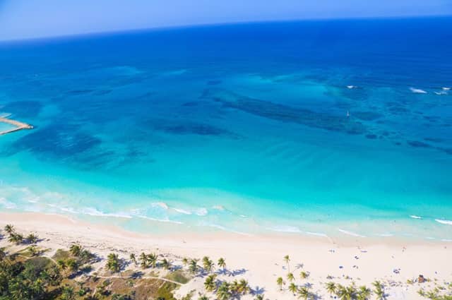Sandy white beach running along the turquoise seas of the Caribbean