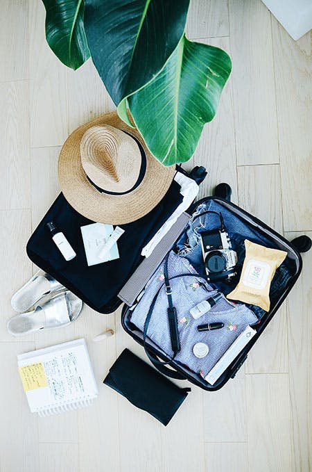 Picture of an open suitcase with travel accessories inside