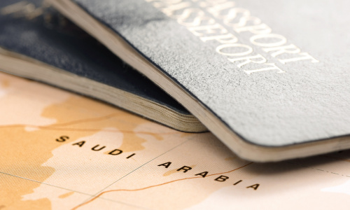 Two passports on top of a map of Saudi Arabia