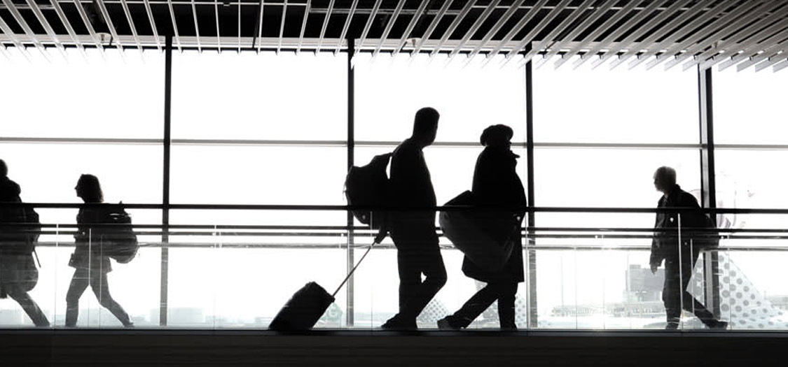 Silhouettes of people walking in an airport