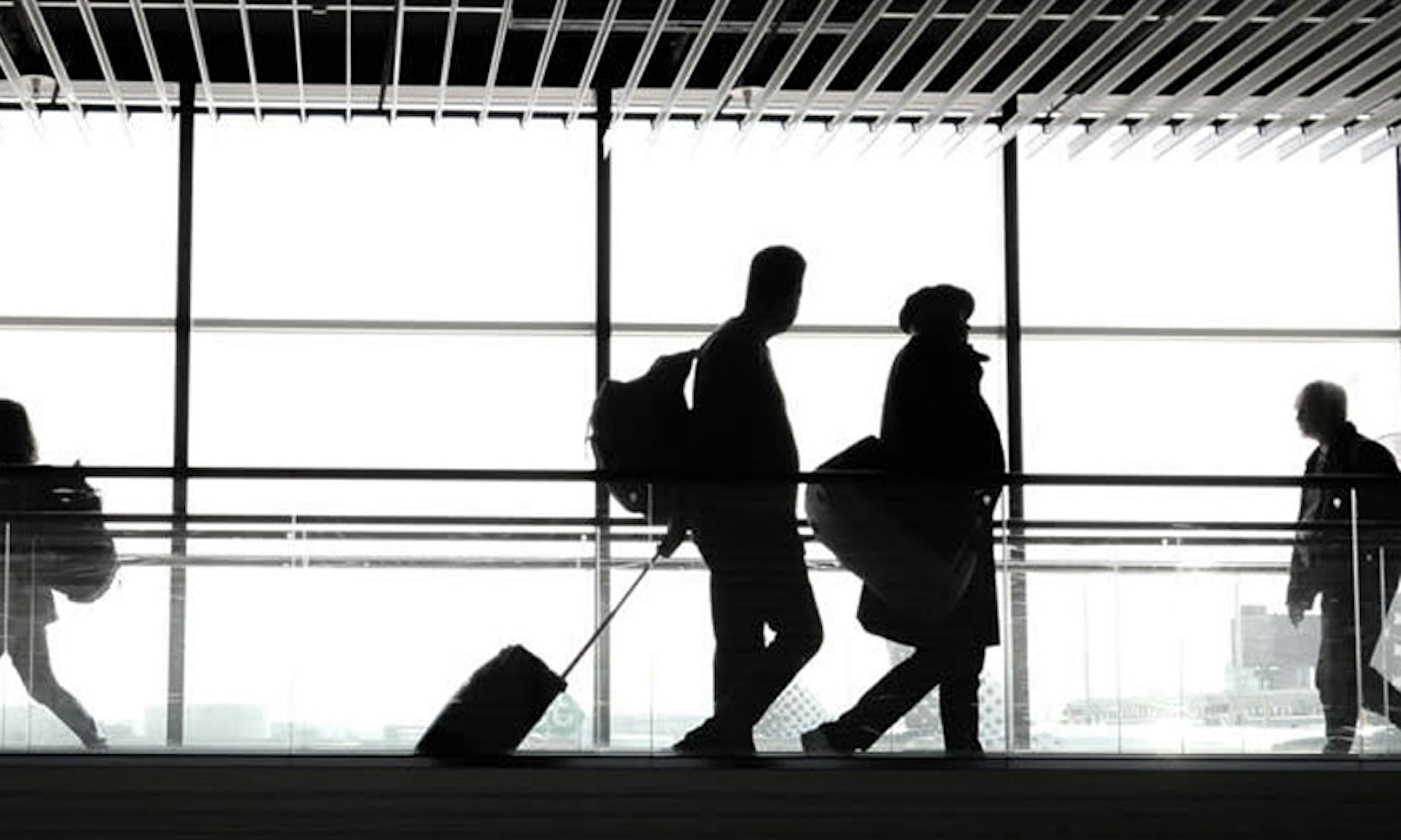 Silhouettes of people walking in an airport