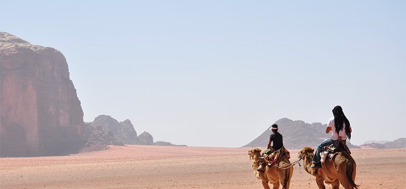 Image of two camel riders in the dessert