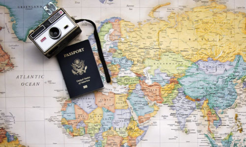A camera and passport positioned on a large map