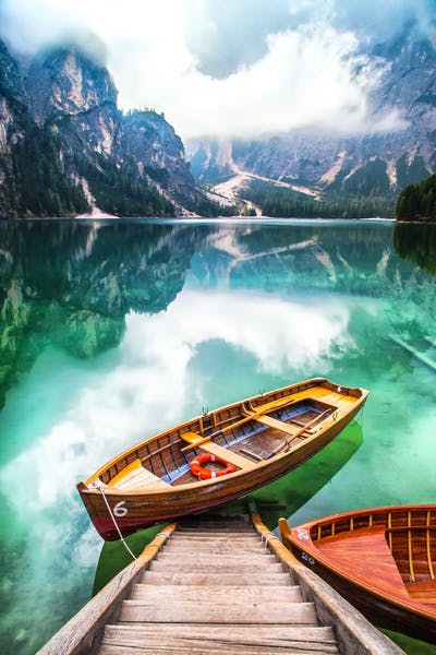 Image of a boat in the water. There are some mountains around the water