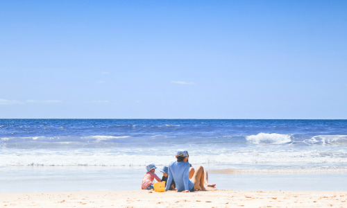 Family sitting on the beach enjoying the lovely weather