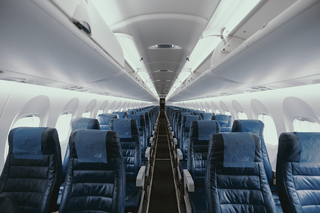 Cabin onboard an aircraft with leather seats and white fixtures